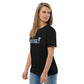 Model wearing the IRACELIKEAGIRL Stanley/Stella Creator unisex tee in Black with the white and sky blue GIRLSGETGRITTY IRACELIKEAGIRL logo on the front
