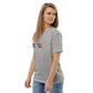 Model wearing the IRACELIKEAGIRL Stanley/Stella Creator unisex tee in Heather Grey with the navy and coral GIRLSGETGRITTY IRACELIKEAGIRL logo on the front